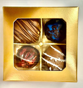 A beautifully arranged box of hand made chocolate truffles collection featuring various flavors and designs.
