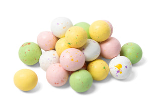 A pile of Speckled Spring Easter Malt Balls in pastel colors of pink, yellow, green, and white on a white background.