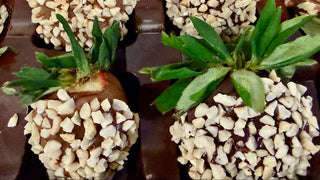 Chocolate Dipped Strawberries with Almonds topped with crunchy almond pieces and fresh green leaves.