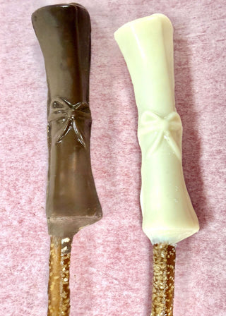 Graduation Chocolate Covered Pretzel Rods with chocolate and white chocolate coating, featuring a bow design.
