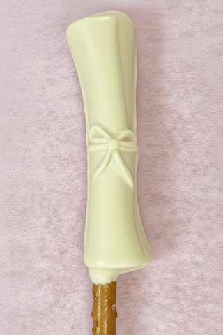 Graduation Chocolate Covered Pretzel Rods decorated with white chocolate resembling a diploma.
