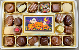 Open assortment with pumpkin-and-ghost image: “Open Halloween chocolate assortment with pumpkin and ghost edible image bar surrounded by assorted chocolates