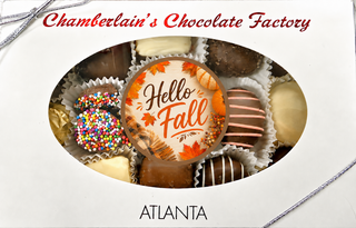 Chamberlain's Chocolate Factory Hello Fall gift box assortment featuring a Hello Fall edible-image chocolate Oreo surrounded by butter creams, caramels, rainbow nonpareils, and assorted chocolates in a white windowed gift box — Atlanta, GA