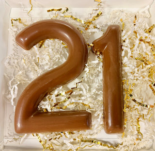 Open gift box with molded milk chocolate number 21 nestled in white and gold paper shred, 21st birthday chocolate gift from Chamberlain's Chocolate Factory

