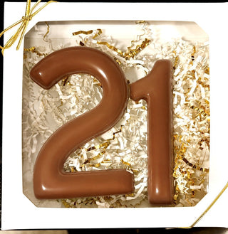 Chamberlain's custom number chocolate gift box with molded milk chocolate number 21 in white and gold paper shred, tied with a gold ribbon bow, 21st birthday gift

