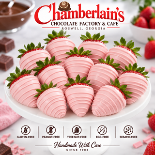 One dozen pretty in pink chocolate dipped strawberries with pink drizzle arranged on a white round plate — elegant pink chocolate strawberry gift box from Chamberlain's Chocolate Factory