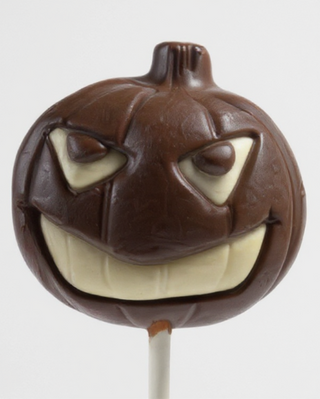 Close-up of a dark chocolate jack-o'-lantern lollipop with menacing white chocolate eyes and grinning face, Halloween chocolate treat crafted in small batches at Chamberlain's Chocolate, Roswell Georgia