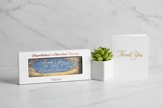 Thank You For Being A Great Tenant artisan chocolate bar gift box on white marble surface next to small plant and thank you card, premium tenant appreciation chocolate gift from Chamberlains Chocolate Factory