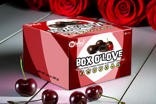 Box of 'Box O'Love' chocolates with cherries and red roses in the background

